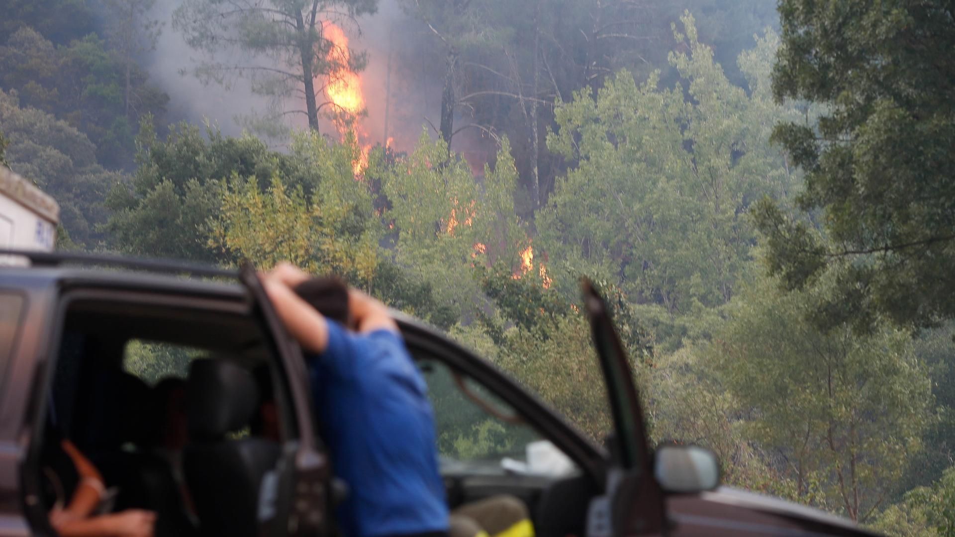 Vecinos ven el avance del fuego, a 25 de agosto de 2025, en A Pobra de Brollón, Lugo, Galicia (España).