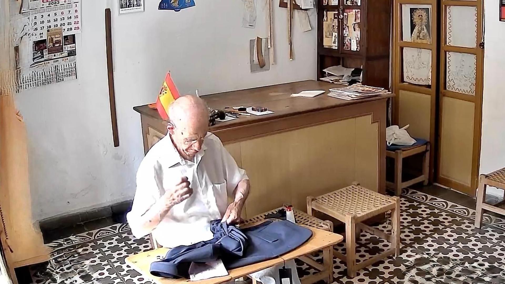 Mario Montes, con 94 años, ayuda a su hijo a arreglar las prendas que vende en su negocio