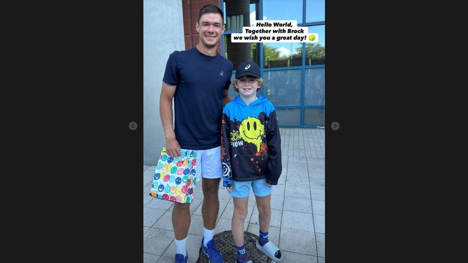 Imagen del tenista polaco Kamil Majchrzak junto al pequeño Brock