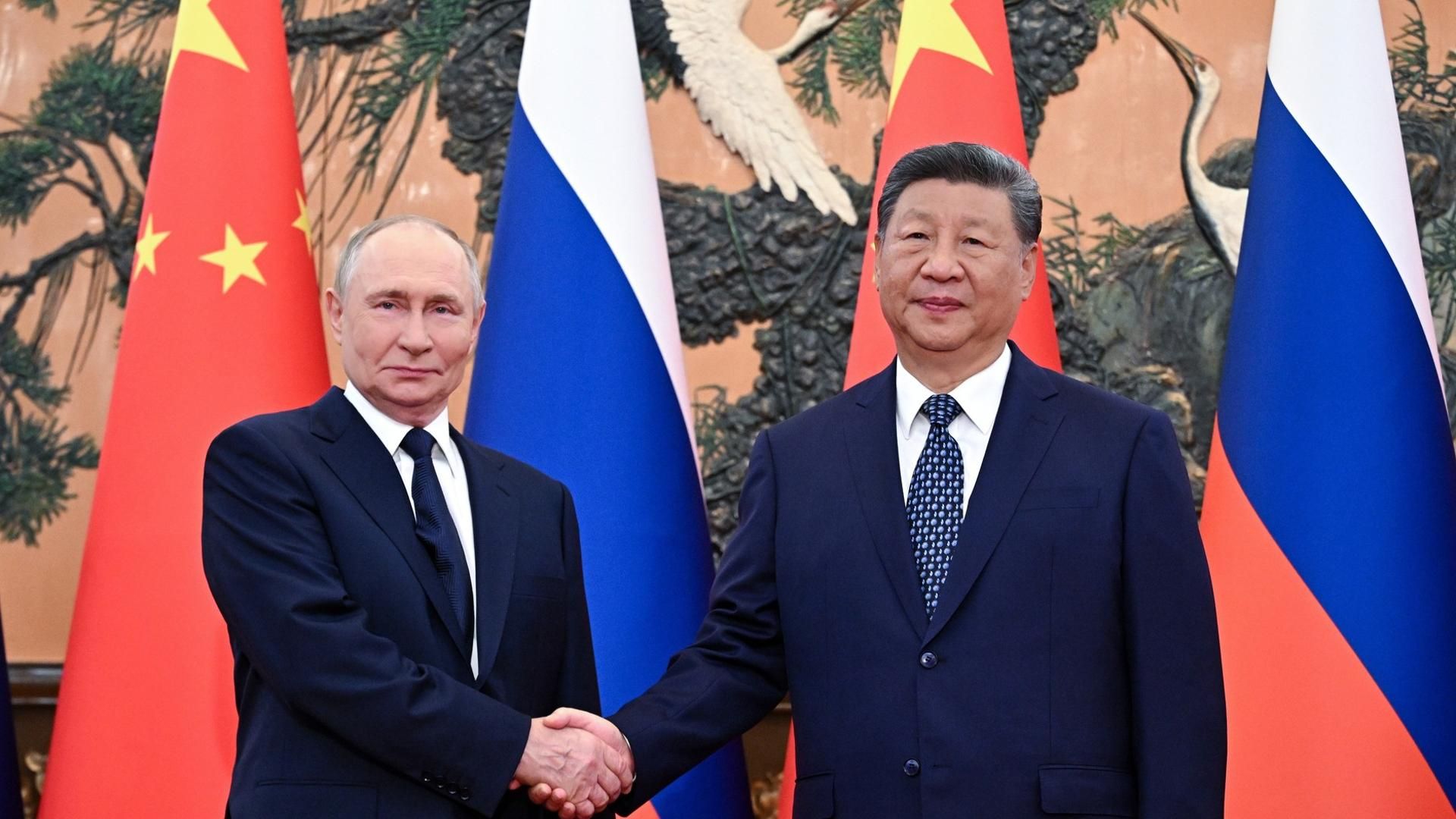El presidente de Rusia, Vladímir Putin (i), estrecha la mano del presidente de China, Xi Jinping (d), antes de su reunión en Pekín, China