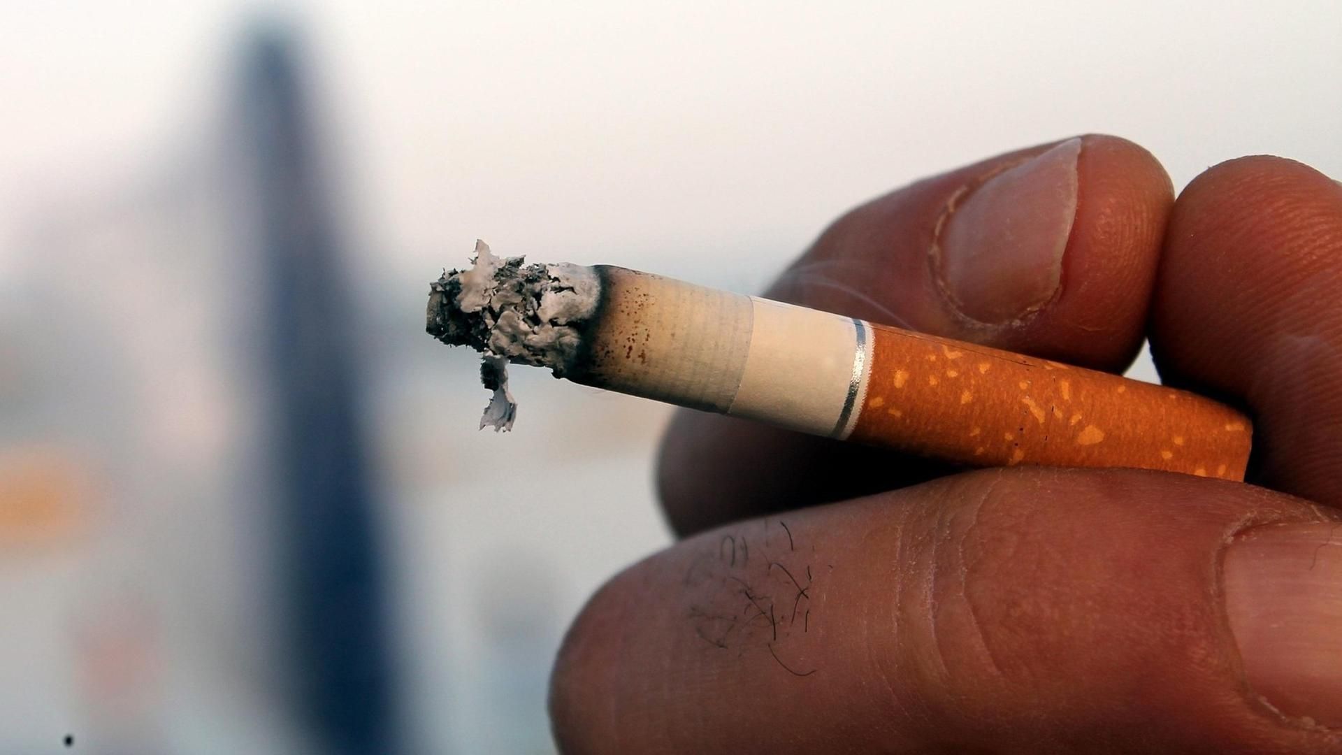 Cigarro en una mano encendido