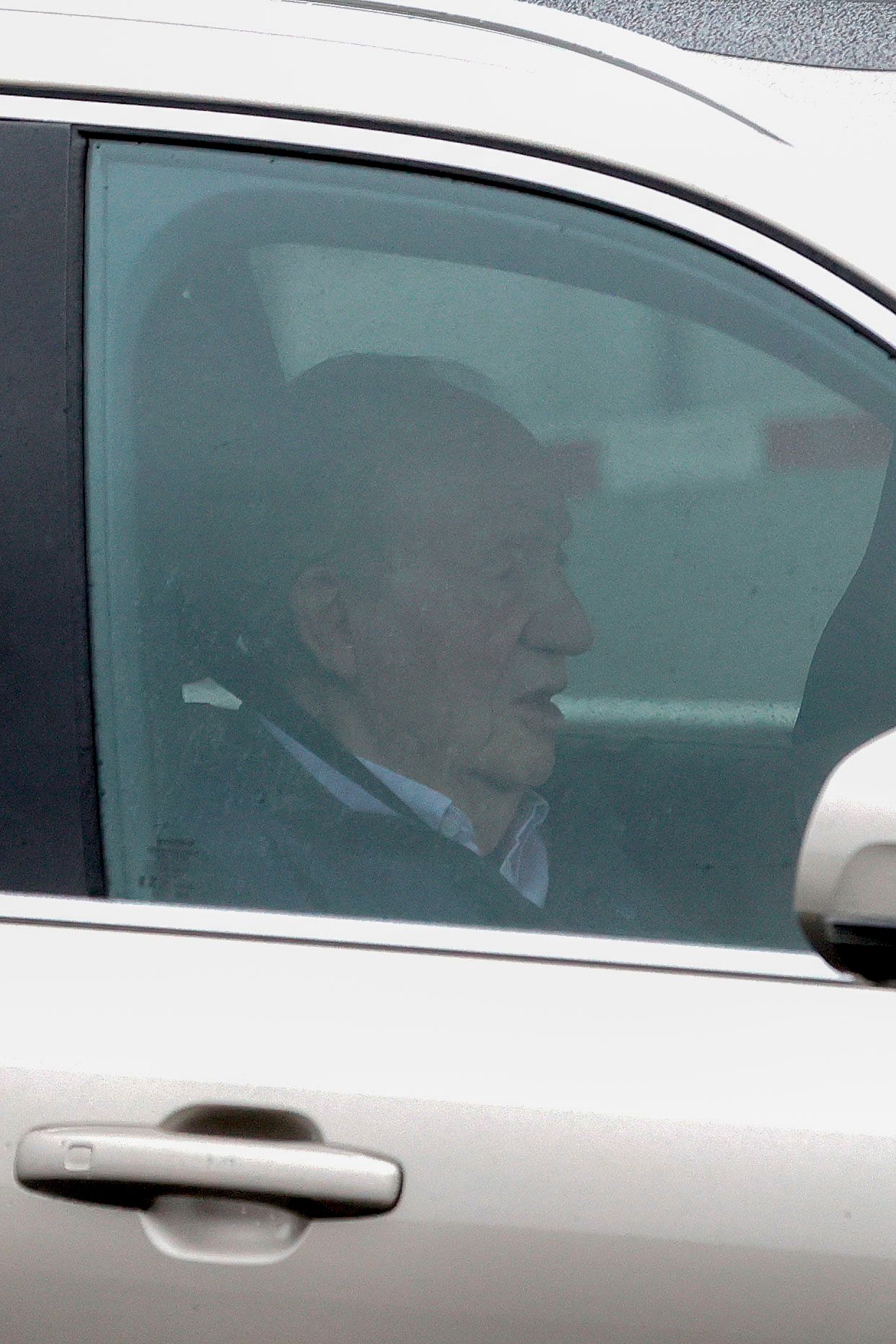 El rey emérito Juan Carlos I a bordo de un vehículo a su llegada este jueves al aeropuerto de A Coruña