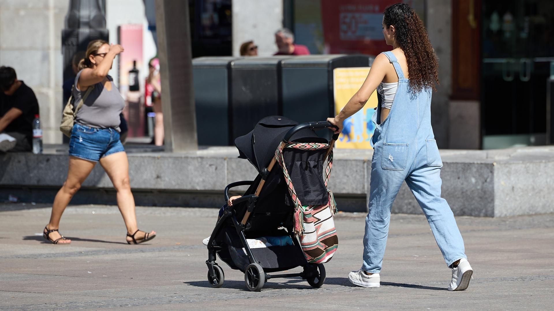 Una mujer pasea con un carrito de bebé
