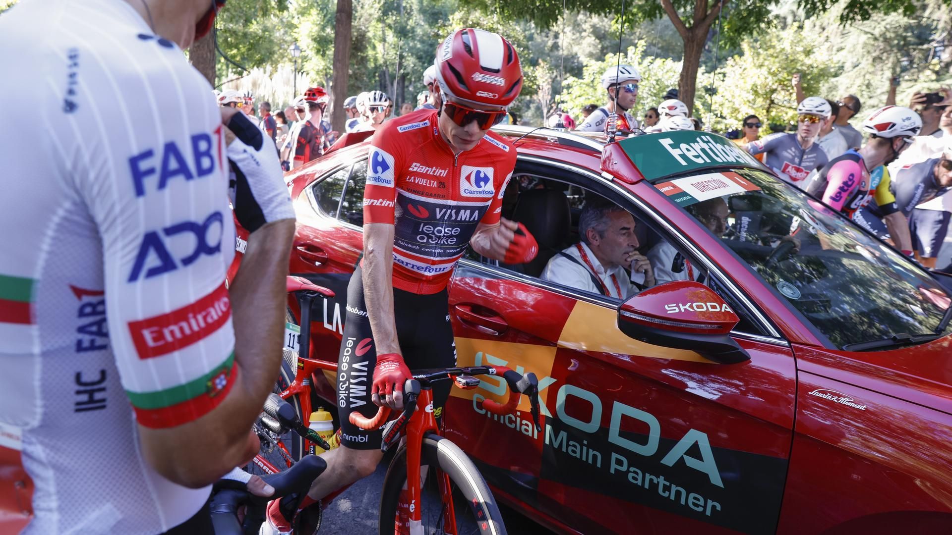 El líder de la general, el danés Jonas Vingegaard (c), junto al coche de Dirección de carrera, durante la última etapa de la Vuelta