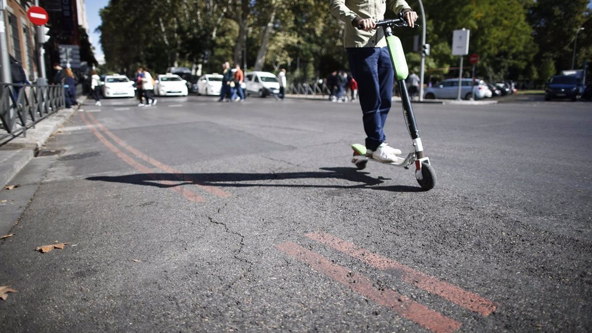 Un hombre circula con un patinete eléctrico por la calzada