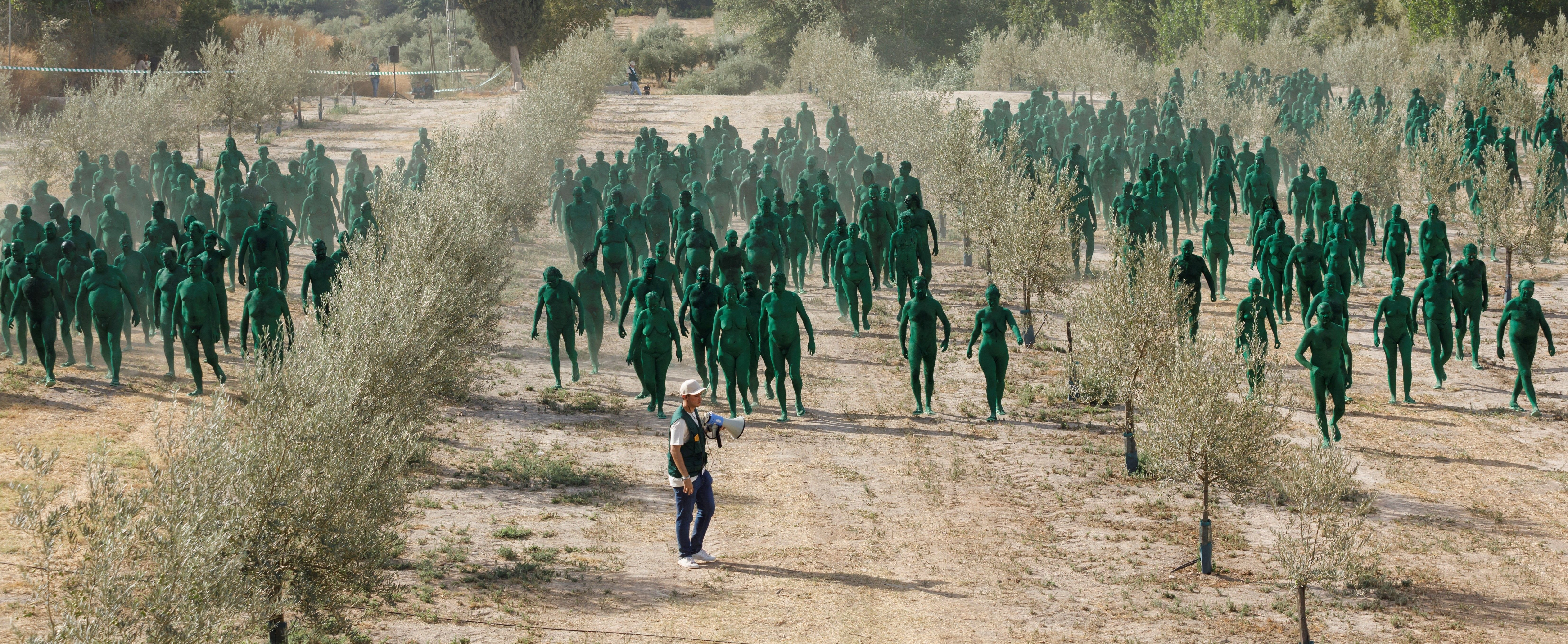 Personas pintadas de verde entre olivos en Granada