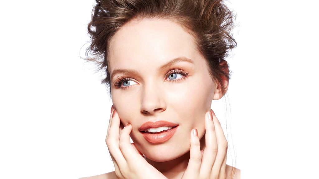 Beautiful brunette girl touching her face with manicured nails