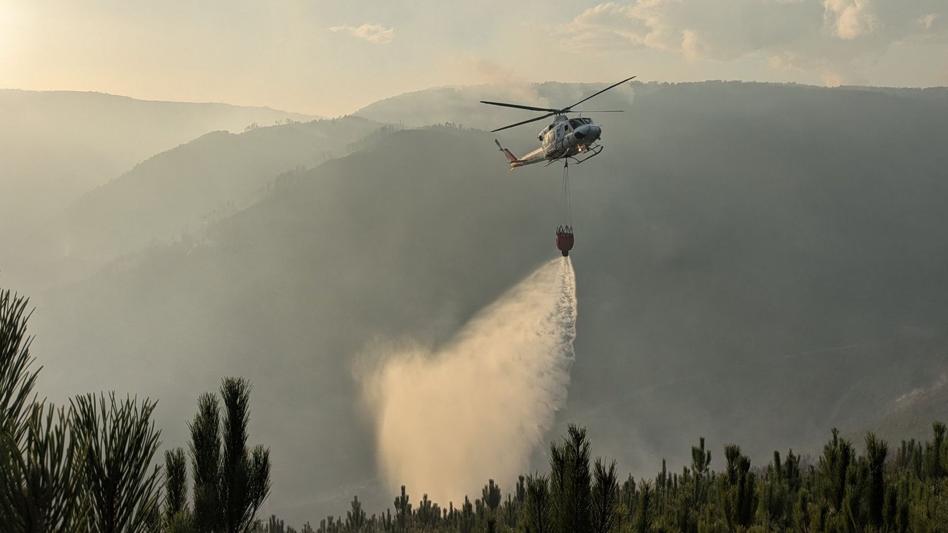 Descarga de agua de un helicóptero en el incendio de Pantón, Lugo