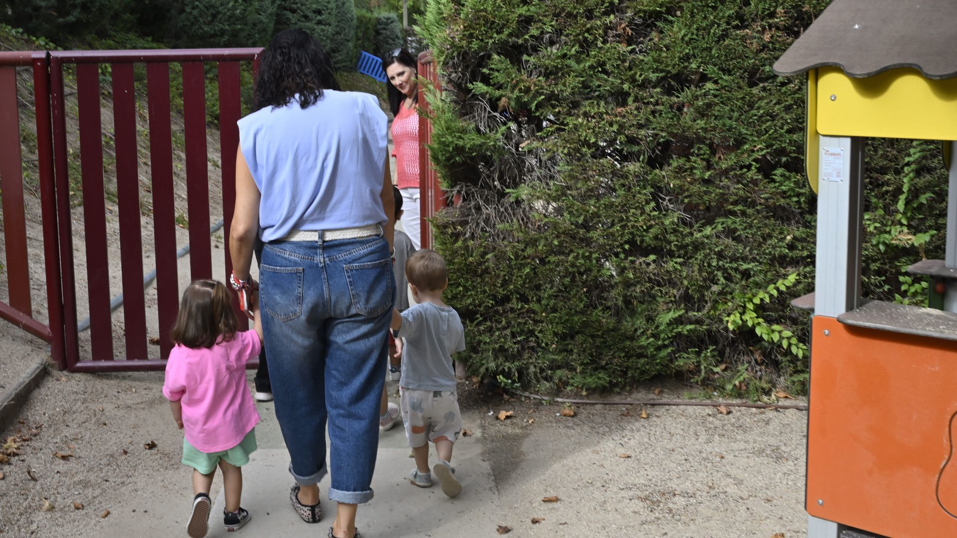 Una madre llevando a sus hijos al cole