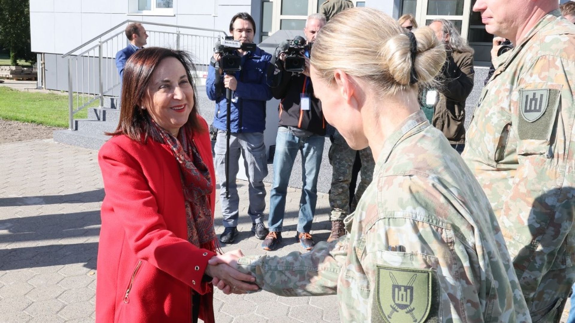Margarita Robles saluda a la ministra de Defensa lituana, Dovilė Šakalienė, en la base militar de Siauliai.