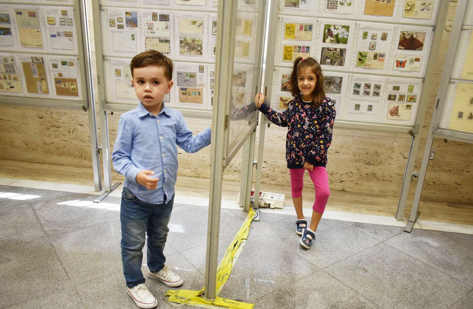 Álvaro, con su amiga Antía, de cinco años mostrando su colección de sellos, expuesta en Ourense