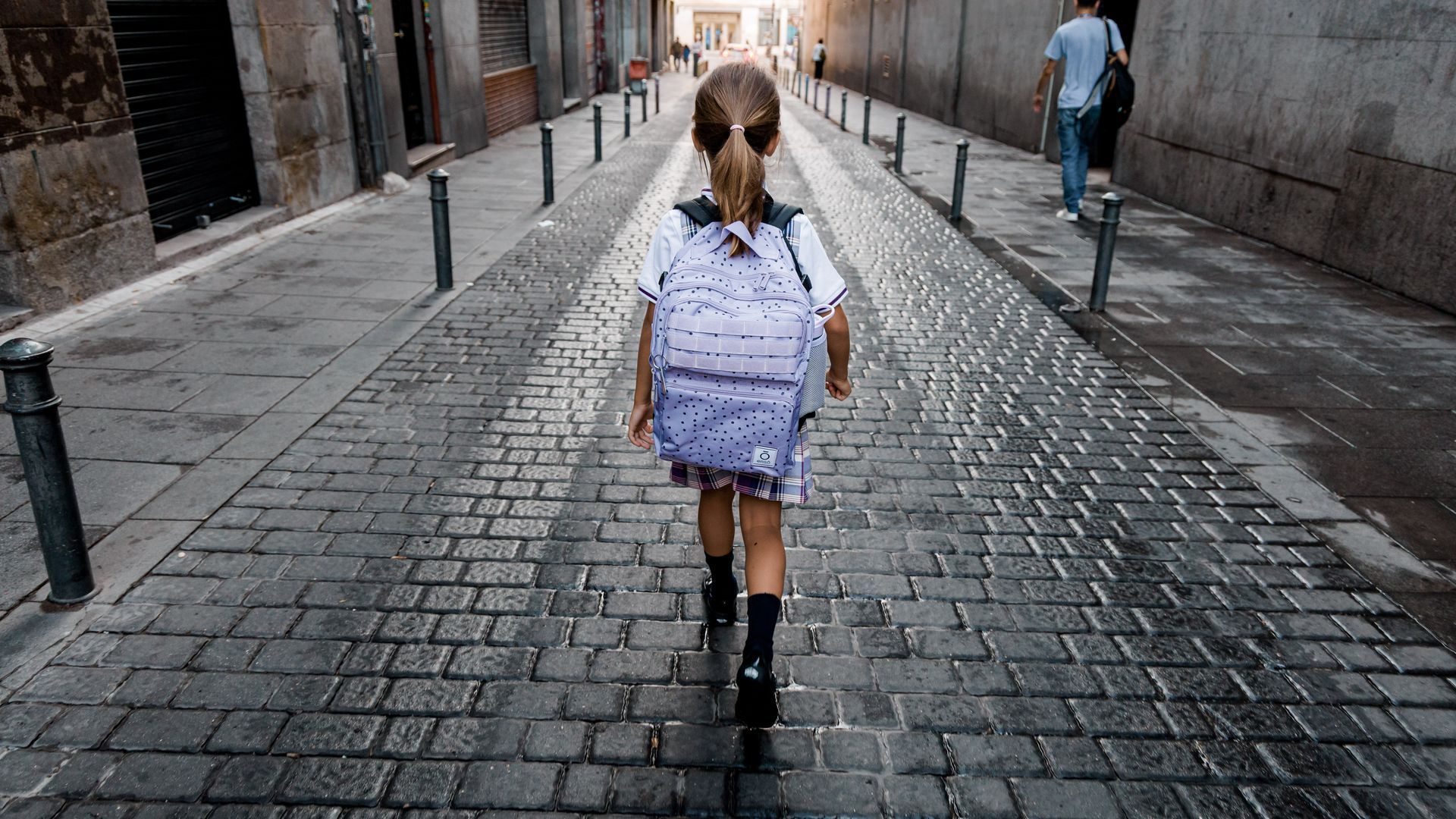 Una niña, ajena a esta información, camina por la calle