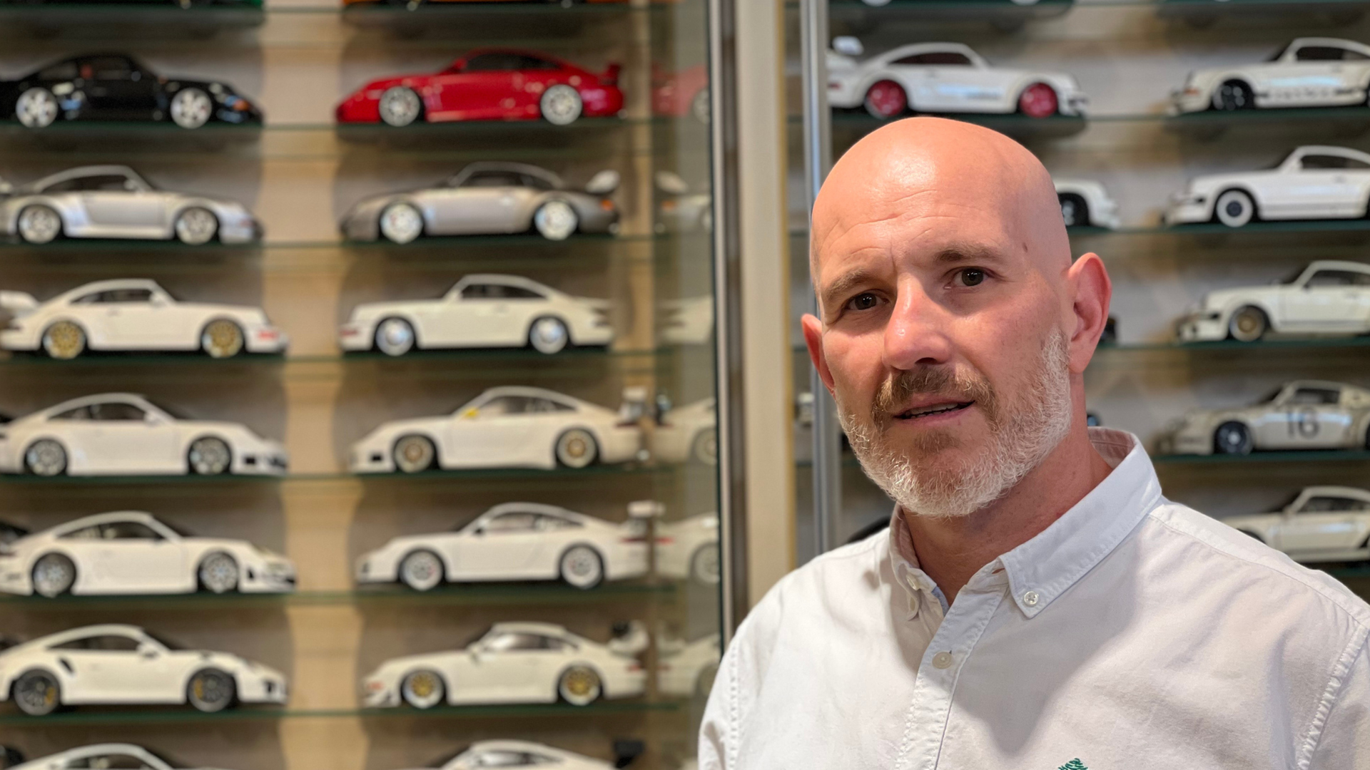 Javier Martín posa una parte de su colección de Porsches de fondo