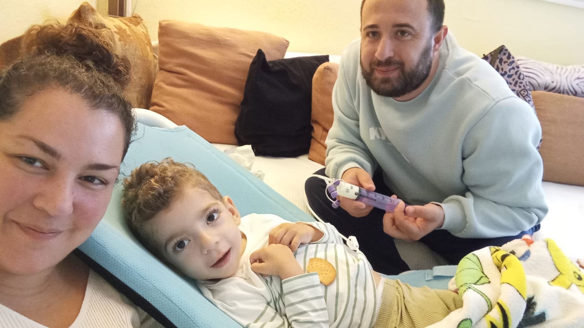 Juan, con leucodistrofia, junto a sus padres, Brenda y Juan Antonio