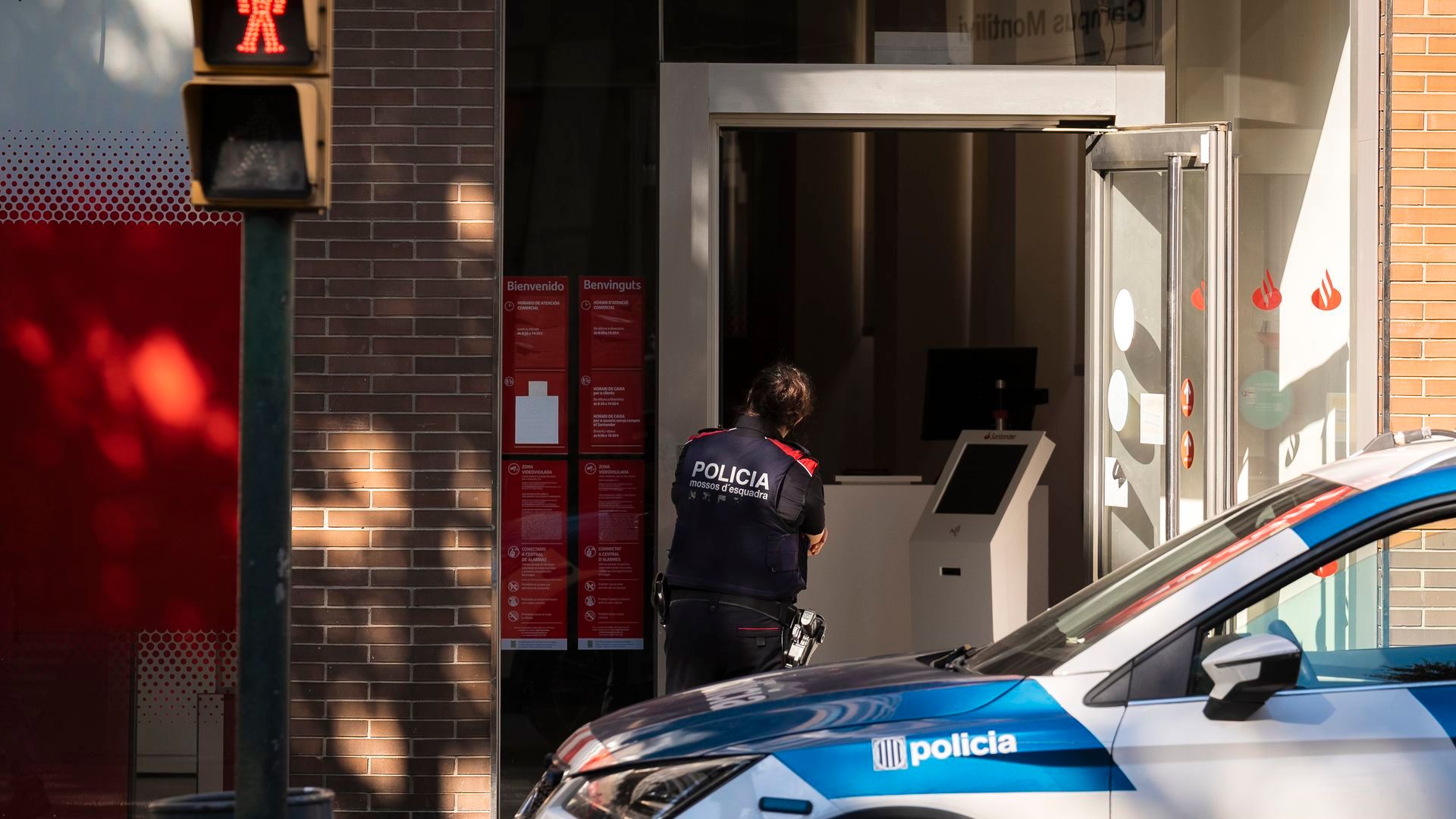 Agente de los Mossos d'Esquadra en el exterior del banco asaltado