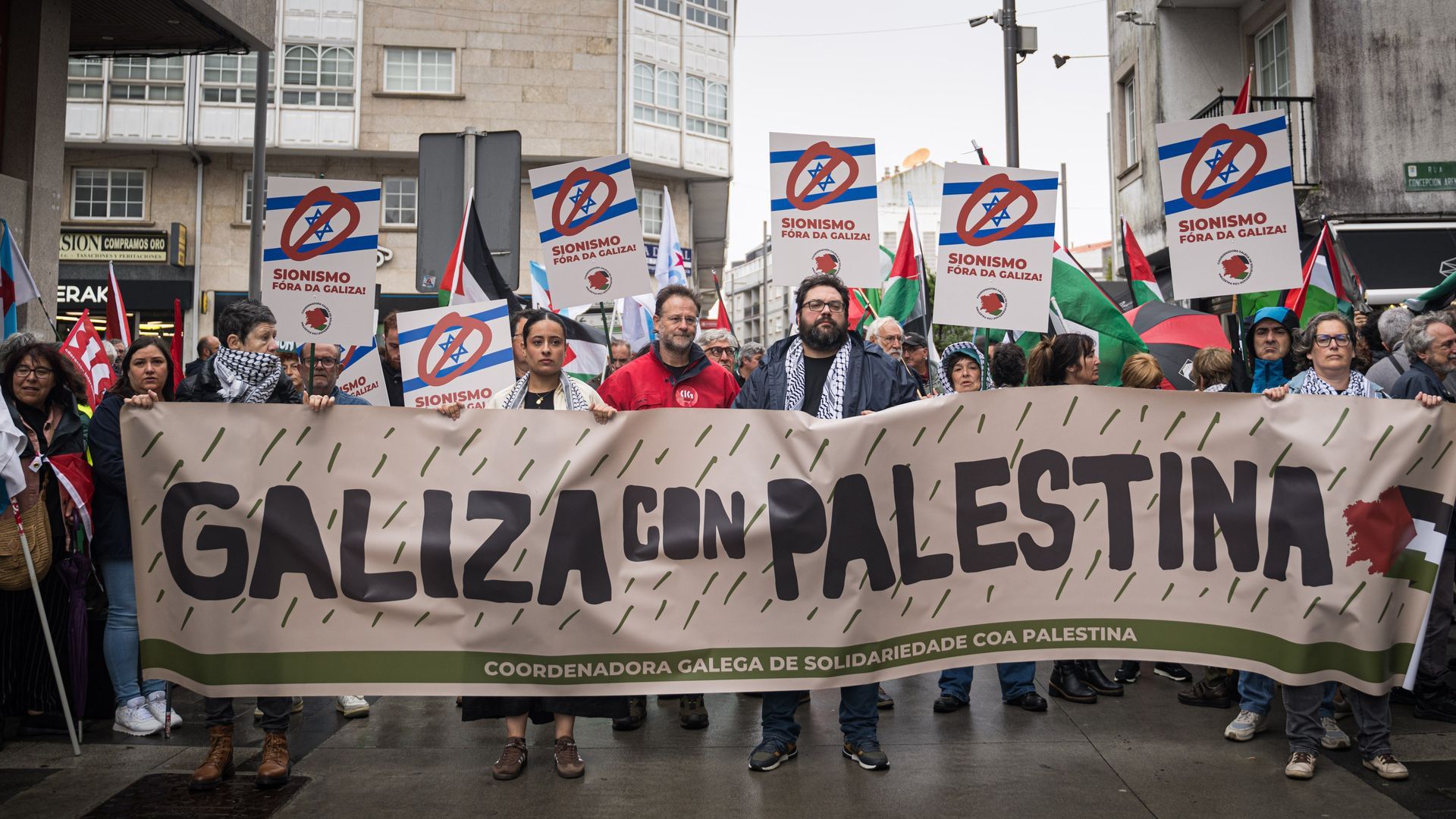Manifestantes portan pancartas durante las protestas ante la presencia de Ehud Olmert, exprimer ministro de Israel en el Foro La Toja