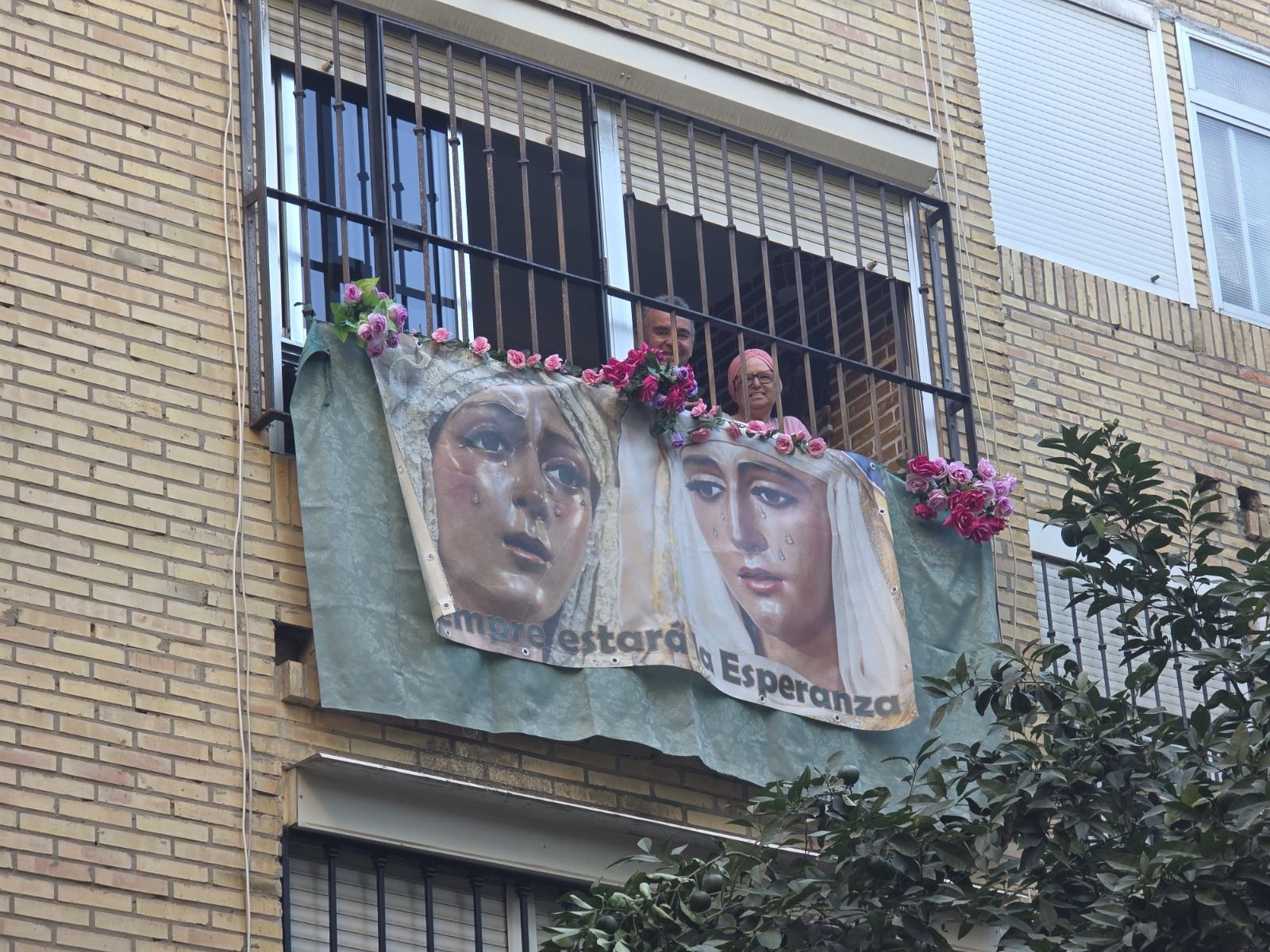 Carmen espera desde su balcón la llegada de la Virgen de la Esperanza de Triana
