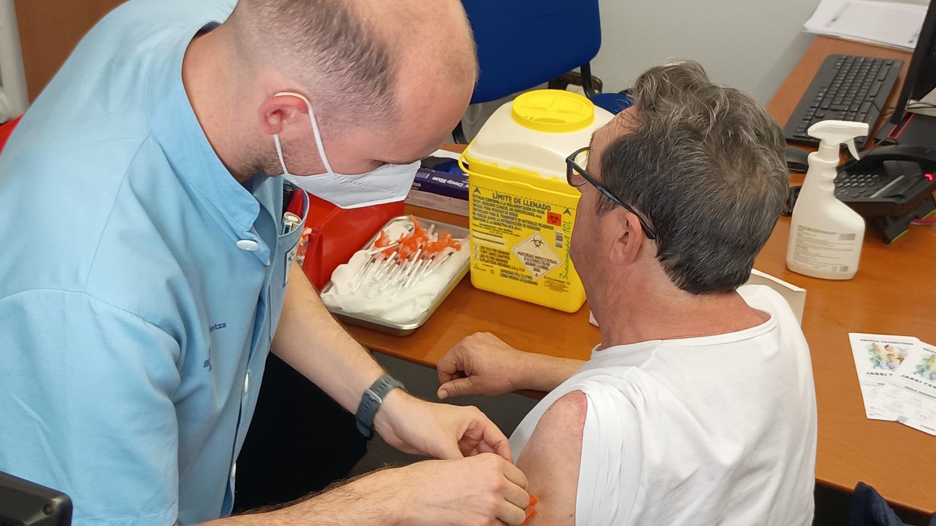 Un sanitario pone la vacuna de la gripe a un ciudadano esta mañana en el Centro de Salud de Amara, Donostia