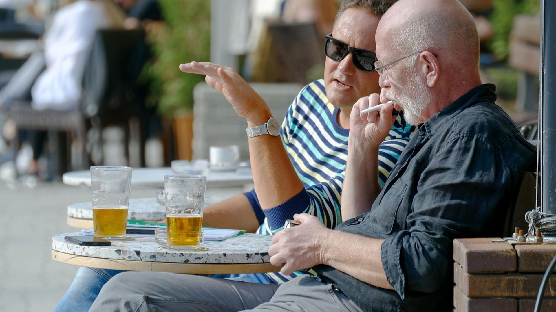 Dos amigos toman cervezas en la terraza de un establecimiento hostelero