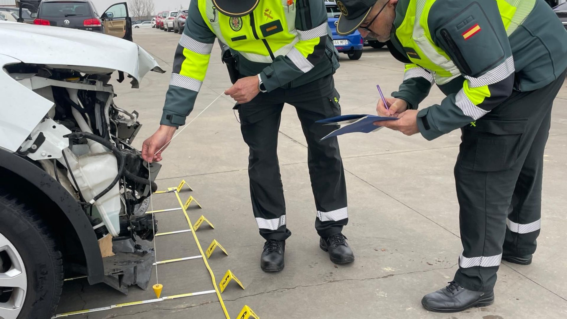Agentes de la Guardia Civil inspeccionan un coche implicado en un accidente