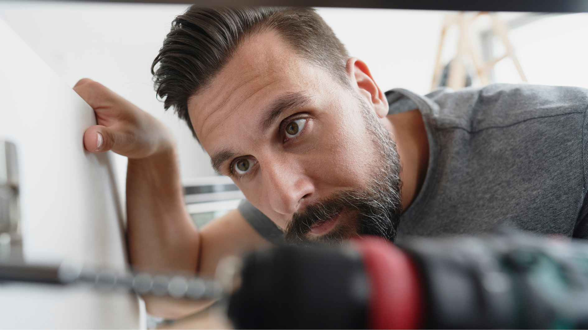 Un hombre con un taladro revisa un agujero en la pared