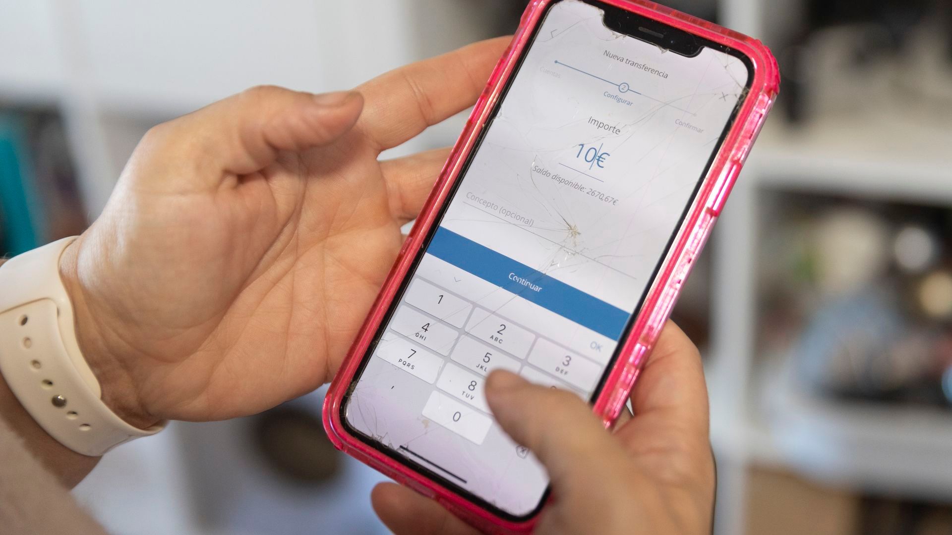 Una mujer realiza una transferencia bancaria con su teléfono móvil