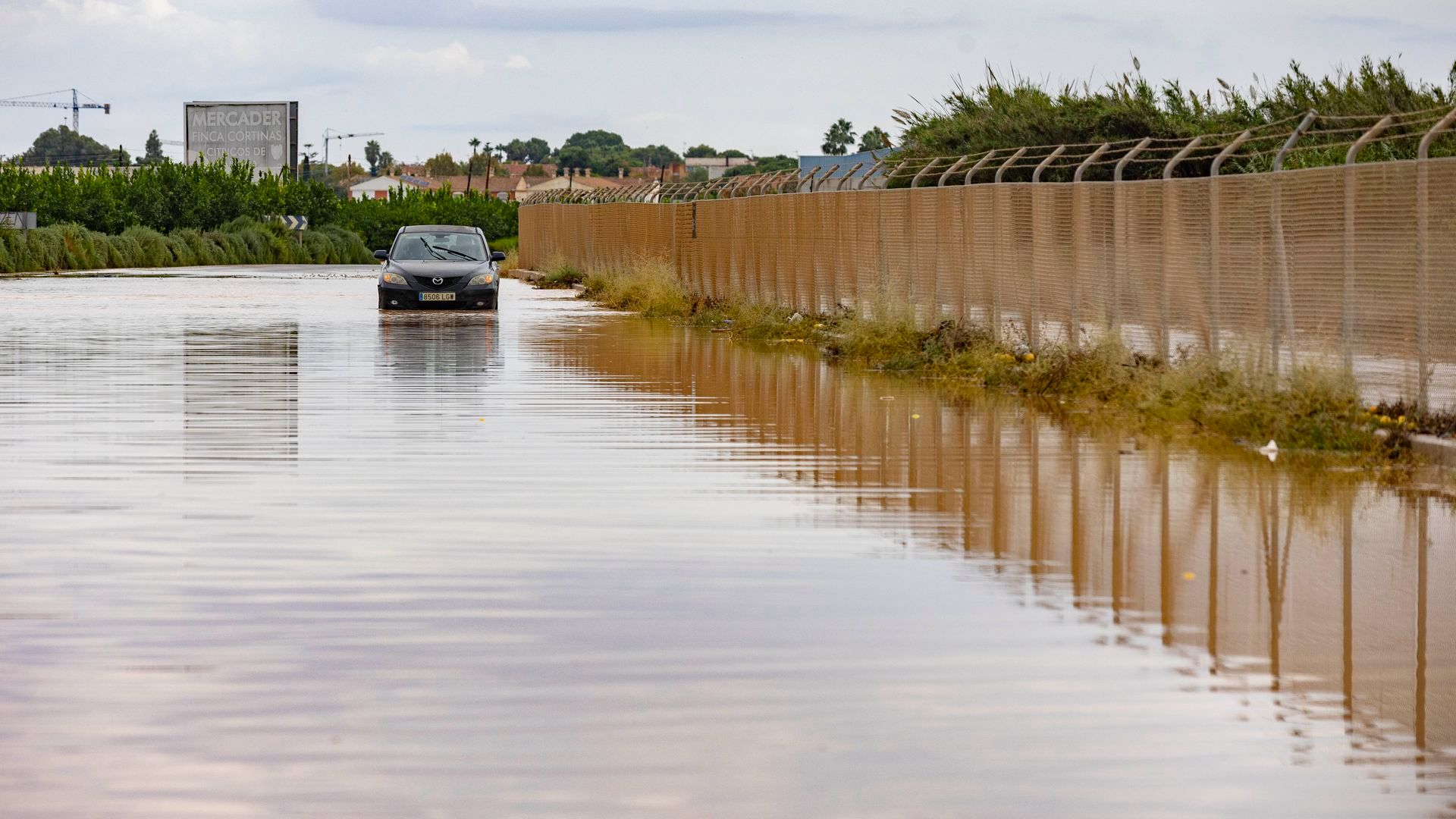 Vista de un coche que ha quedado atrapado por el agua en la carretera RM F-34 de San Javier (Murcia)