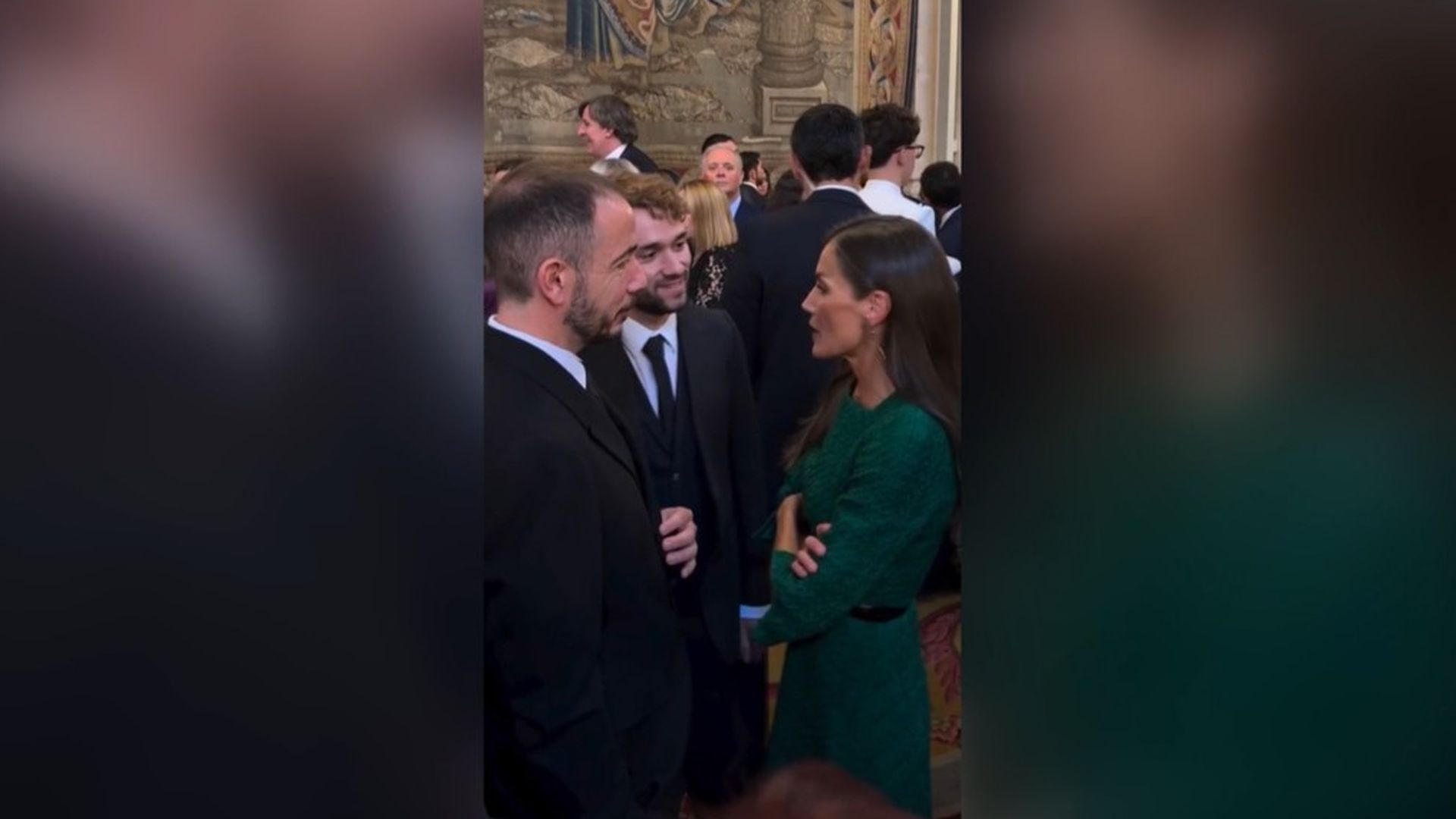Doña Letizia charla con dos de los asistentes al besamanos con motivo del 12 de octubre