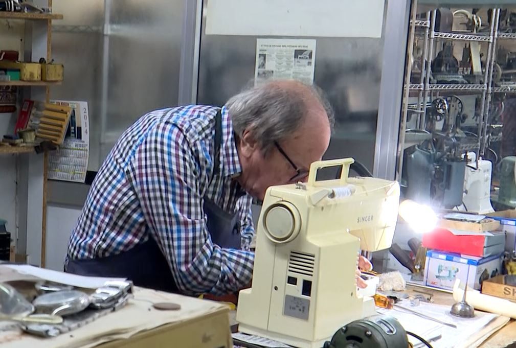 Juan reparando una máquina de coser