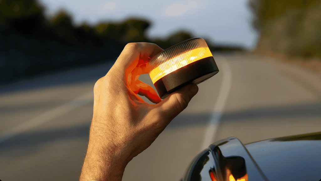 Un conductor coloca la baliza V16 en su coche