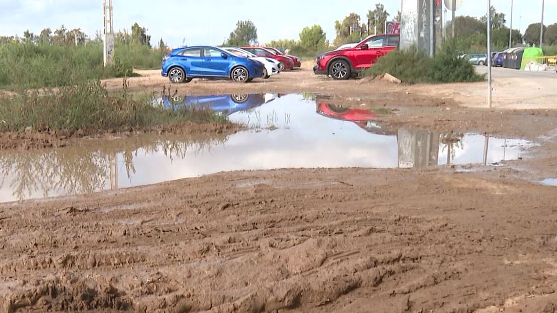 Coches aparcados en solares llenos de barro para evitar las multas