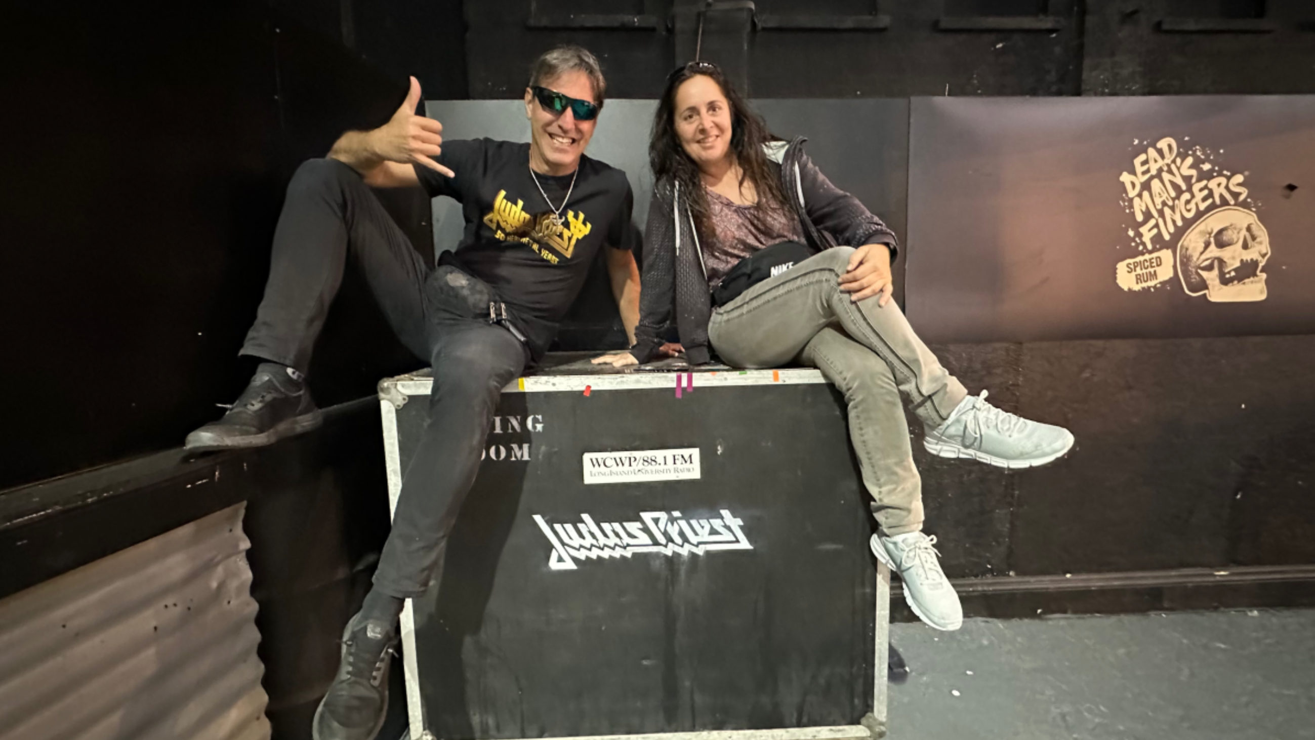Marta y Héctor posan con en logo de su banda favorita, Judas Priest