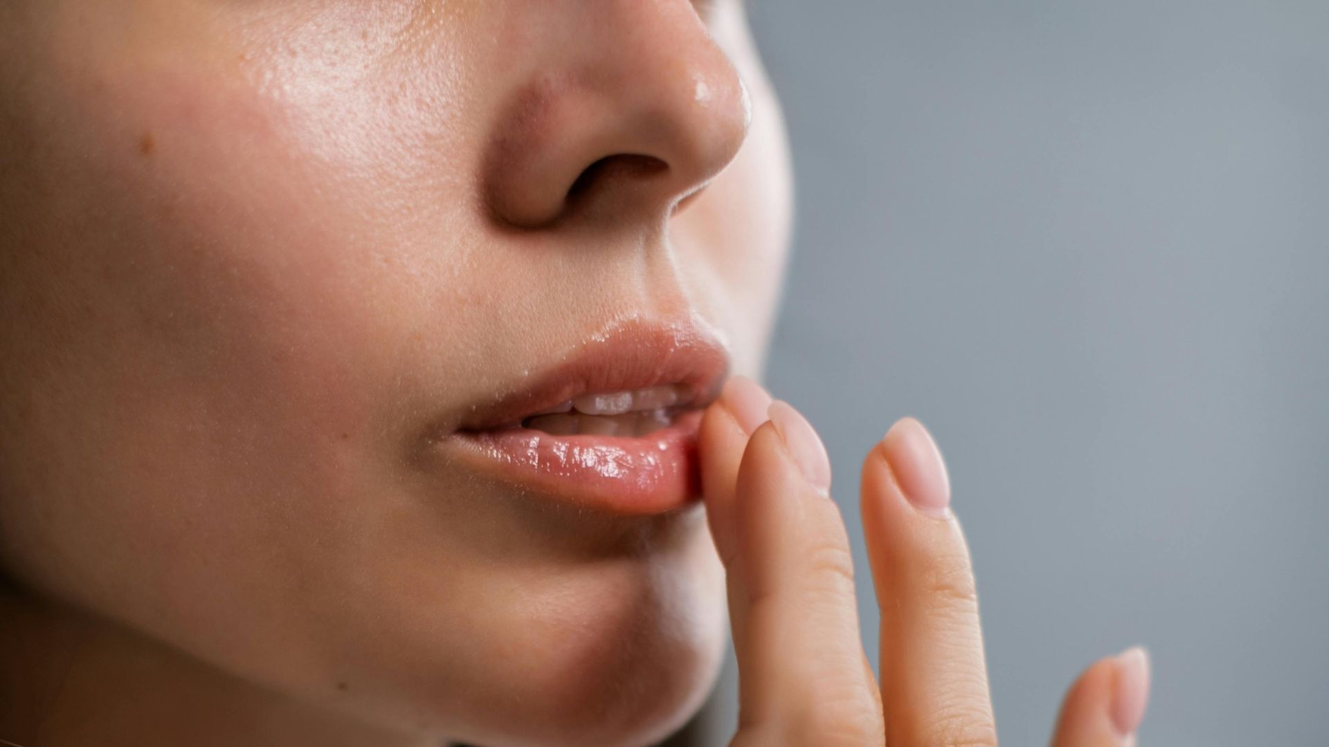 Mujer aplicándose gloss Mujer aplicándose gloss