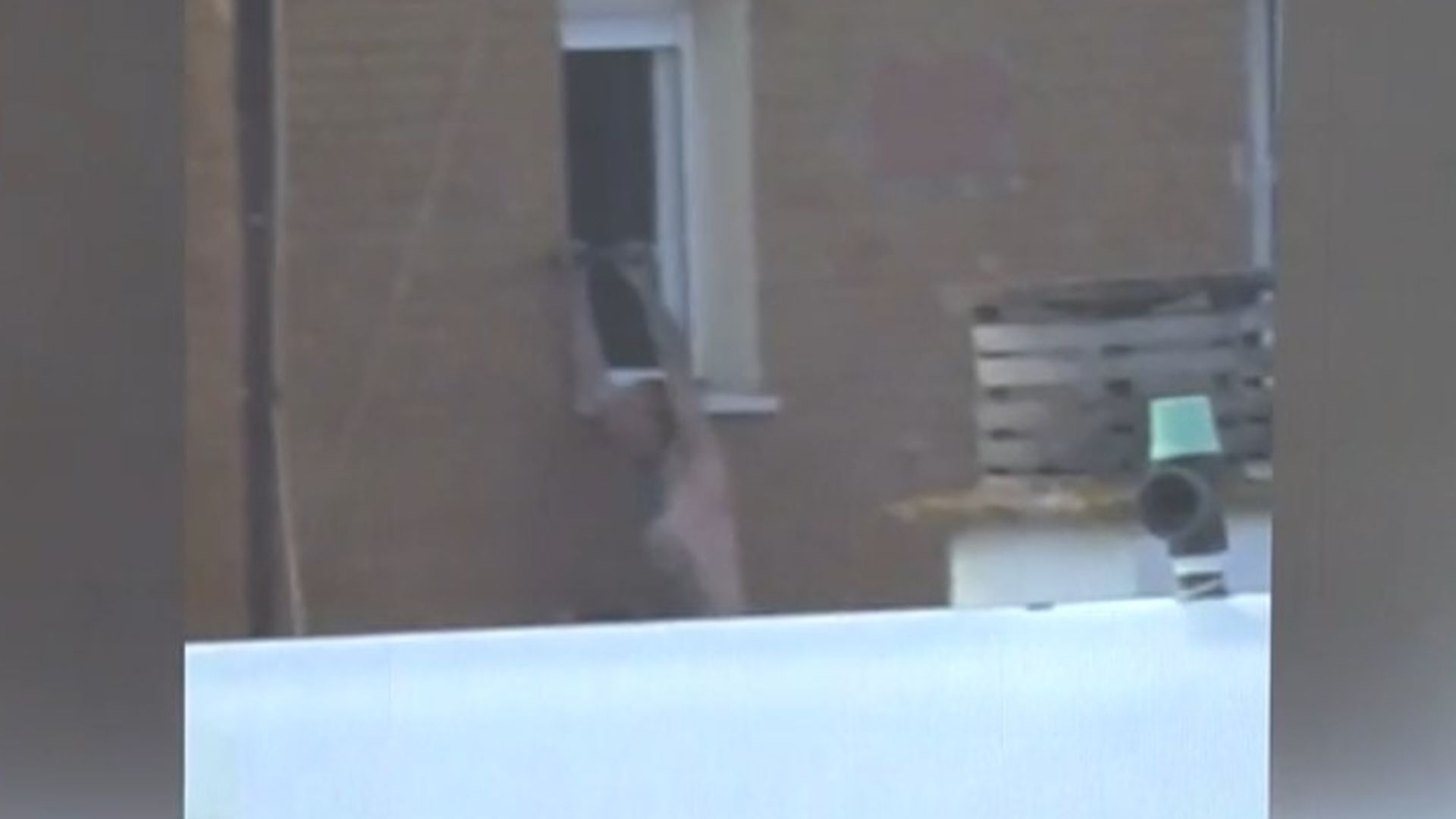 El hombre atrincherado, colgándose al exterior de una ventan