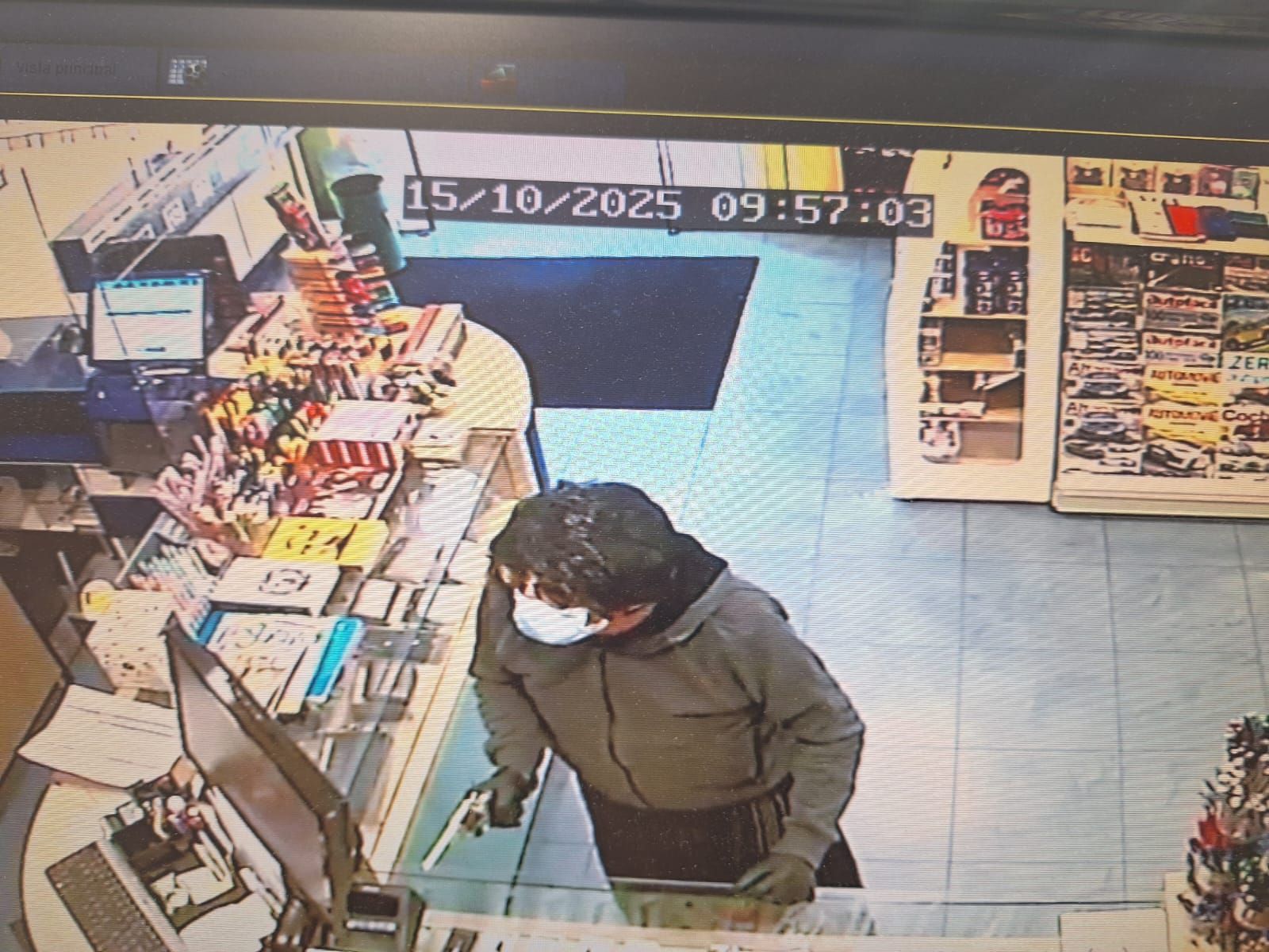 El atracador empuñando una pistola en la librería Corel de Noalla