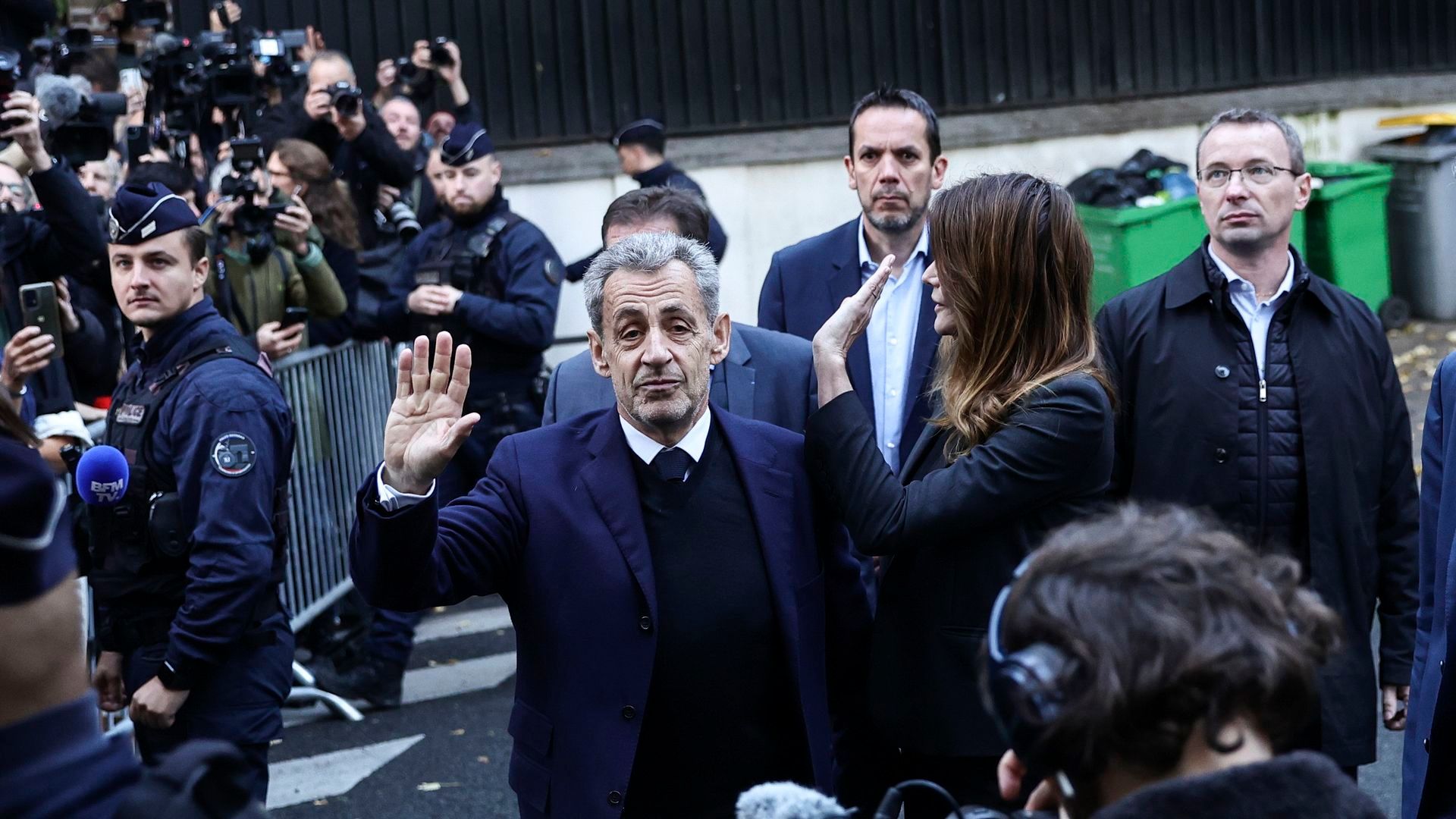El expresidente francés Nicolas Sarkozy y su esposa, Carla Bruni, saludan a la gente el día de su ingreso en prisión durante una manifestación en su apoyo en París