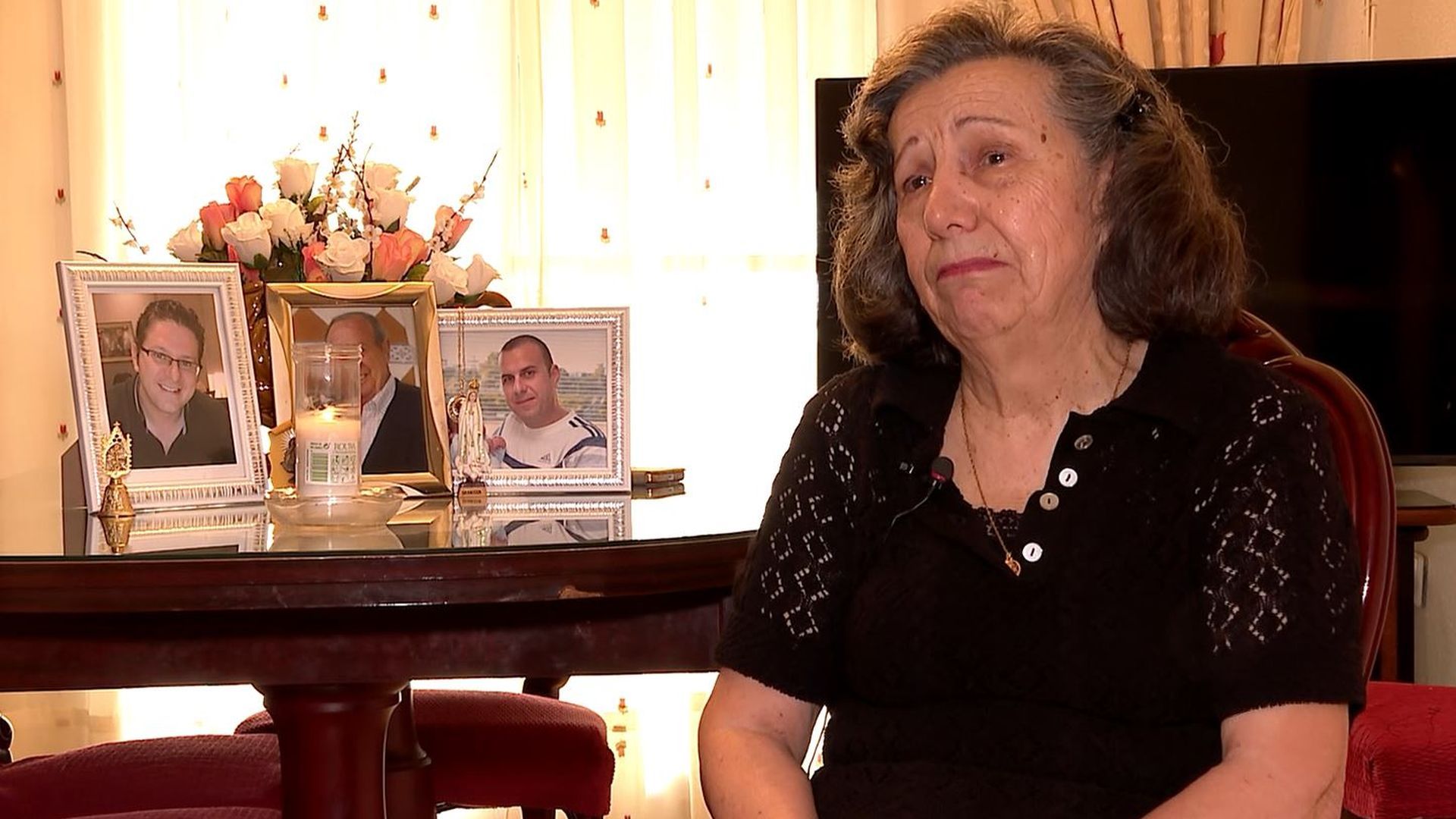 Dolores llora junto a la foto de su marido y sus hijos