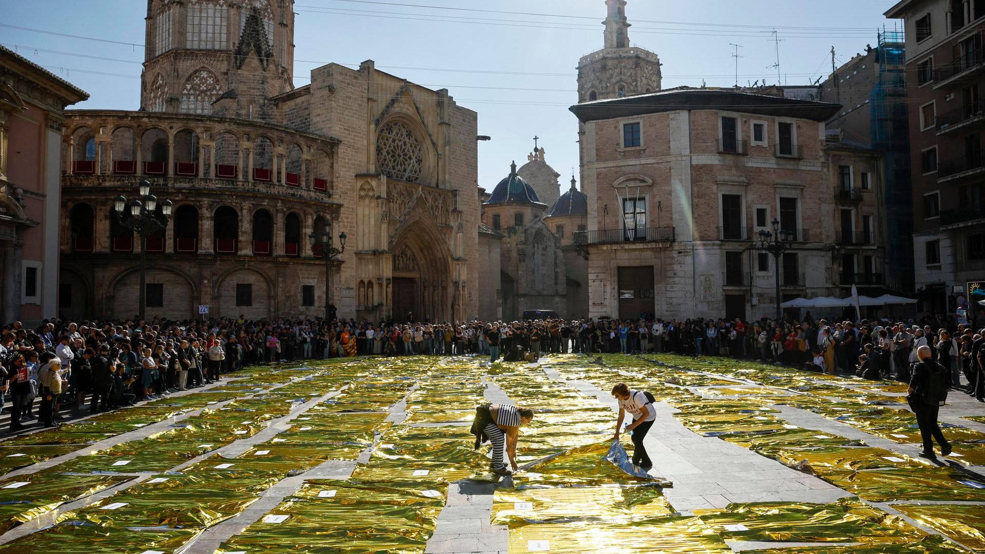 Doscientas veintinueve mantas térmicas han tapizado este miércoles el suelo de la zona central de la Plaza de la Virgen de València, frente al Palau de la Generalitat,