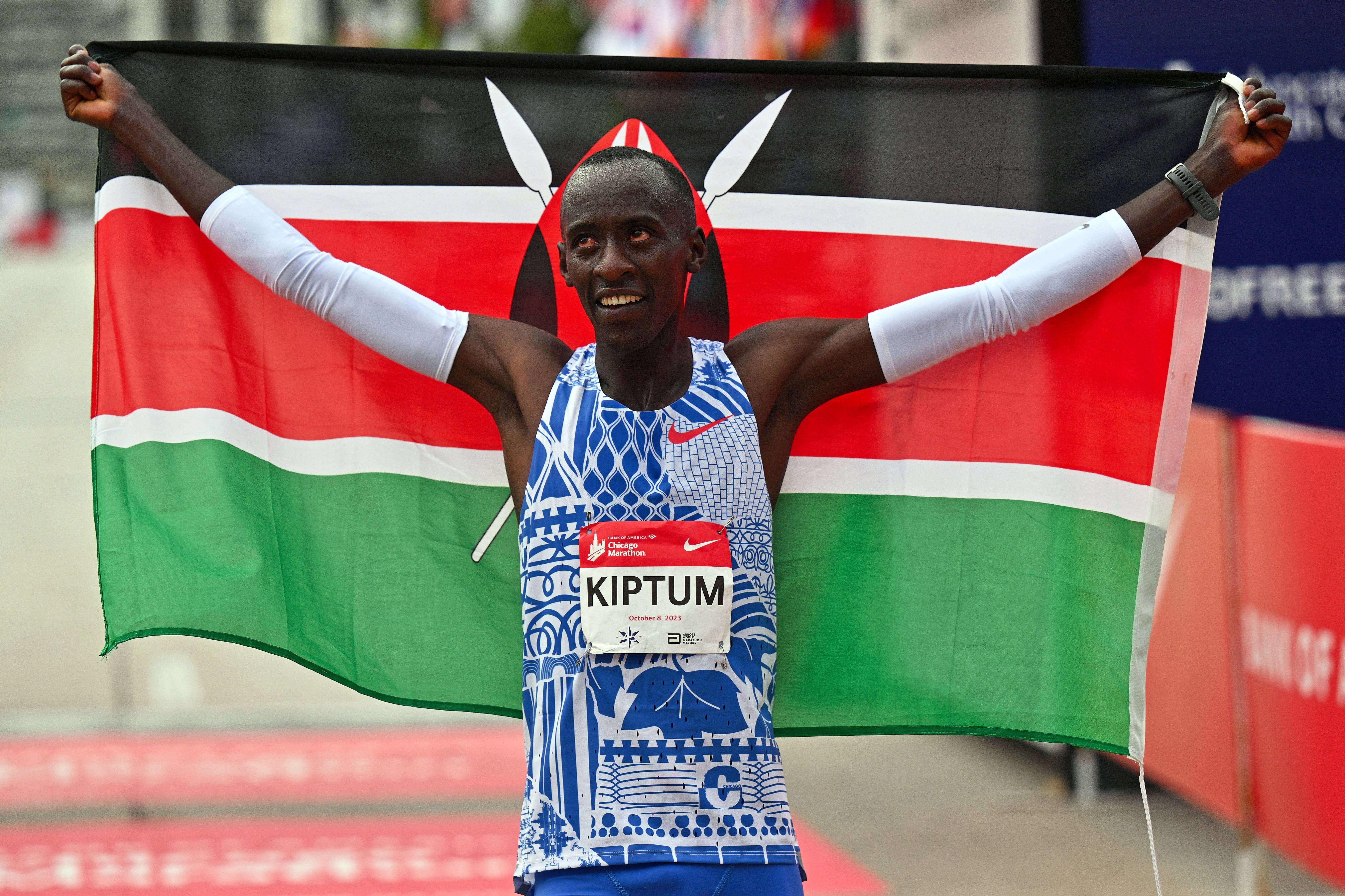 Kelvin Kiptum celebra una victoria con la bandera de Kenya.