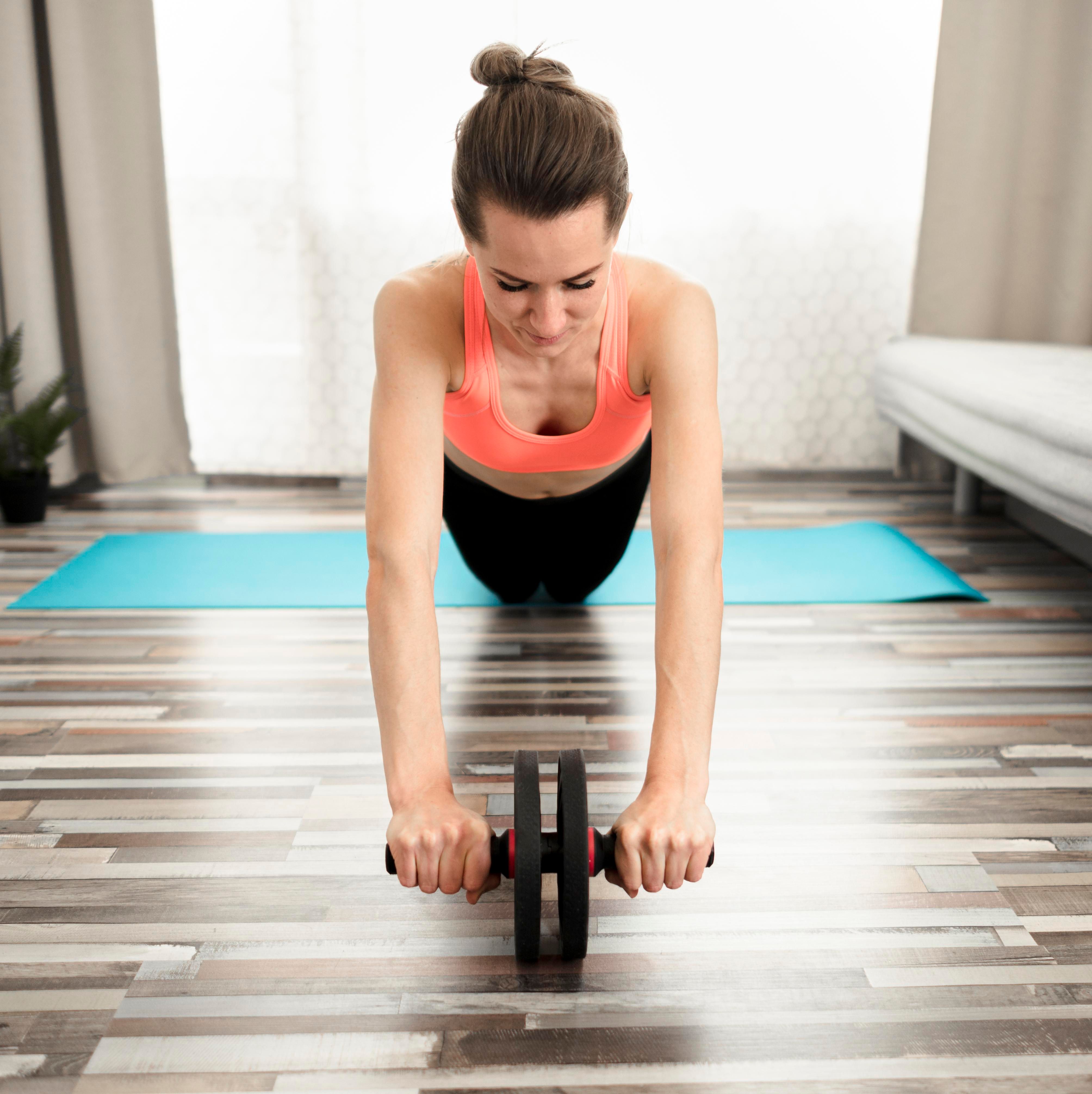  Mujer trabajando el abdomen con la rueda abdominal.