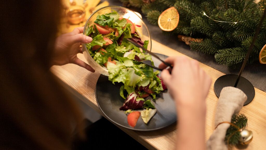 Persona comiendo ensalada en una cena de Navidad
