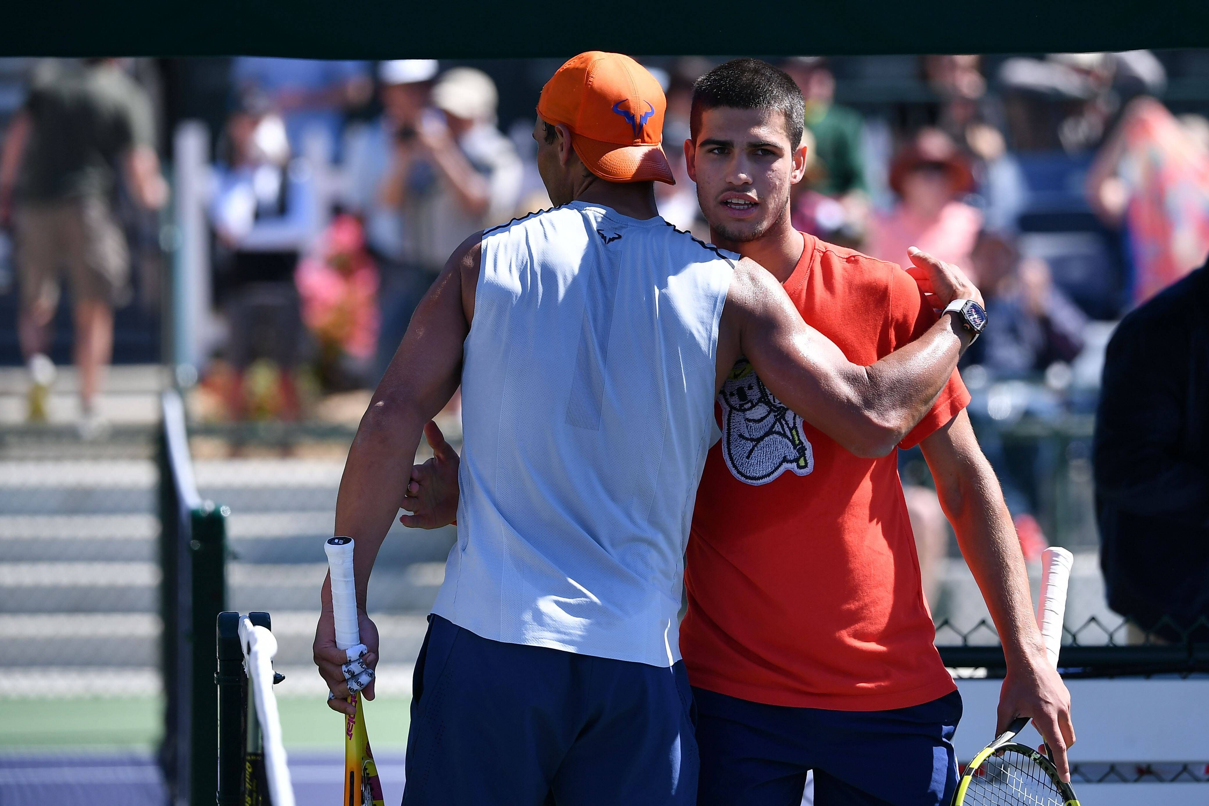 Rafa Nadal y Carlos Alcaraz se saludan tras un entrenamiento juntos.