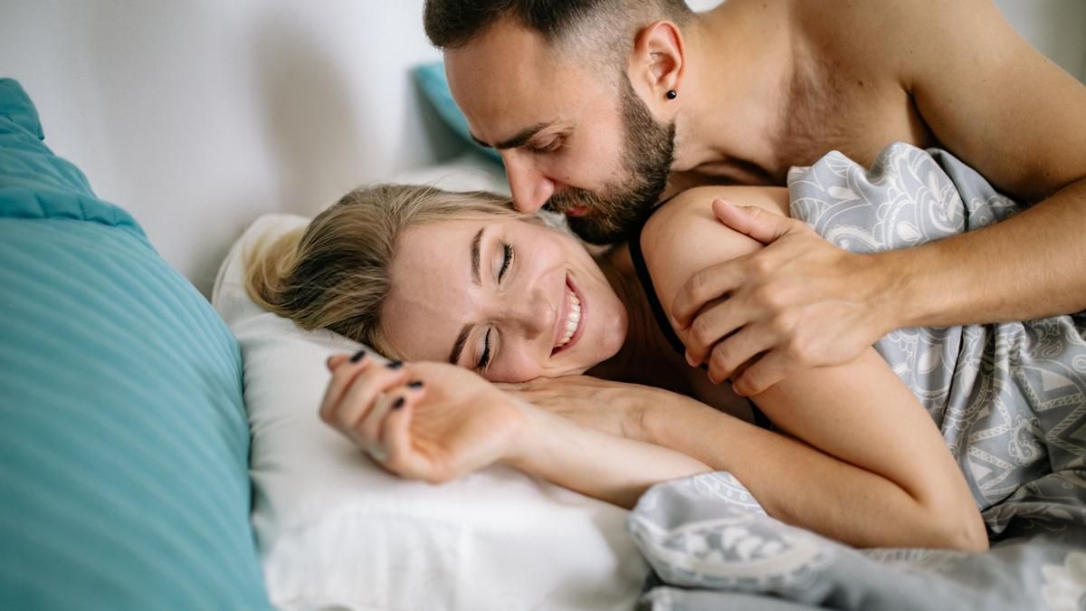 Hombre y mujer en la cama besándose