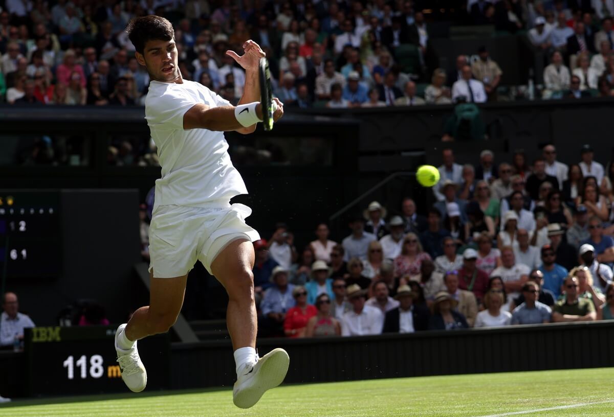  Carlos Alcaraz golpea la bola ante Oliver Tarvet en Wimbledon 2025.