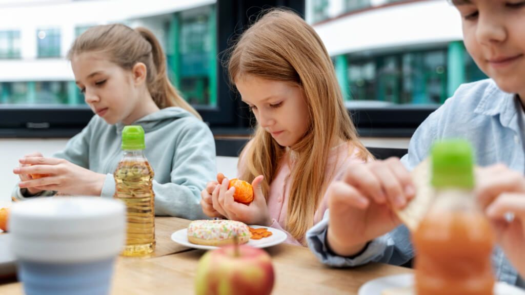 Alumnos tomando el almuerzo en un comedor escolar