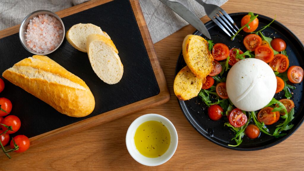  Plato con pan, tomates cherry y queso burrata (Freepik)