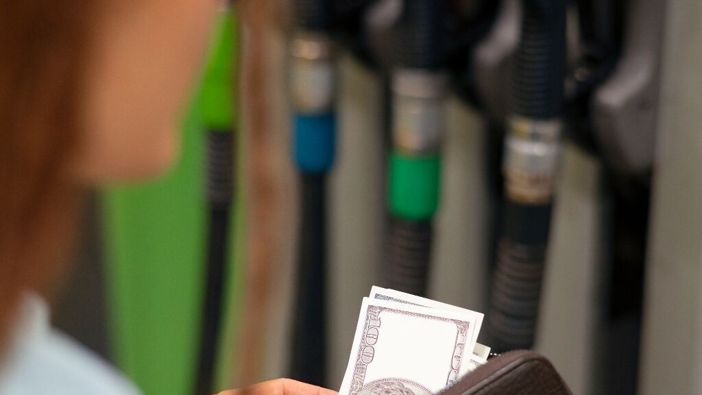 Una chica pagando en una gasolinera tras repostar (foto: Free pik).