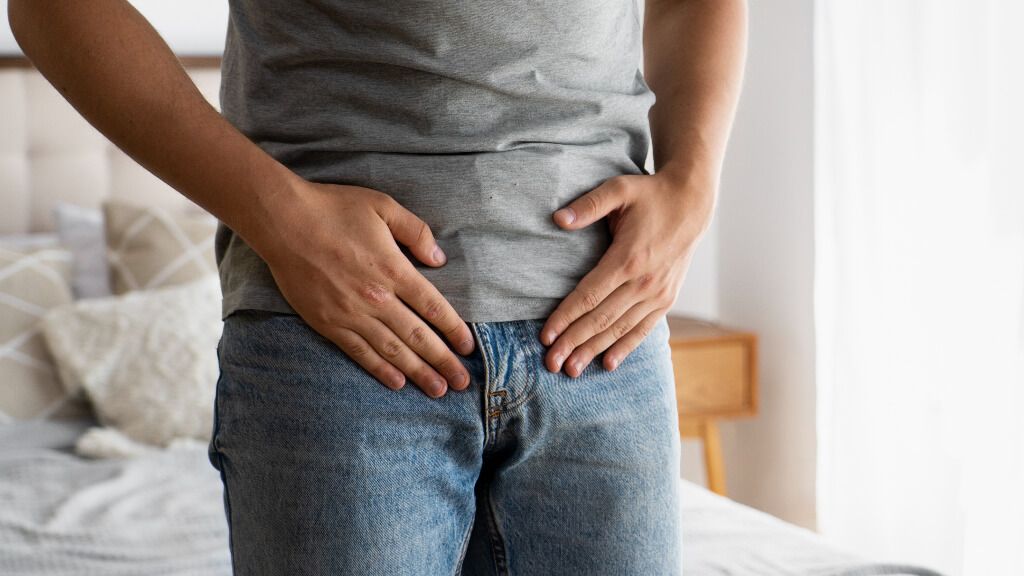  Hombre con las manos sobre su pelvis