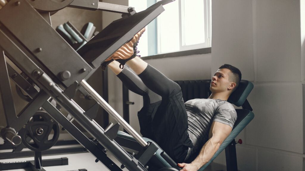  Hombre en el gimnasio haciendo prensa
