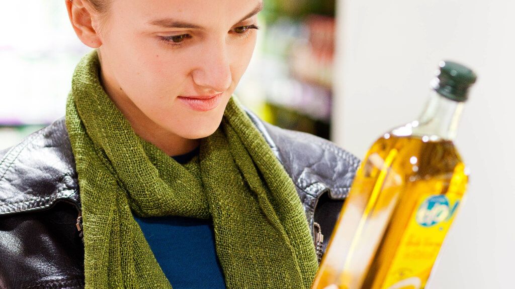 Mujer leyendo los ingredientes de un aceite
